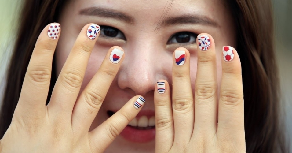 Torcedora com unhas pintadas nas cores da Coreia do Sul posa para foto antes do jogo em Cuiabá