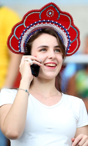 17.jun.2014 - Torcedora da Rússia fala ao telefone enquanto a equipe joga contra a Coreia do Sul, em Cuiabá