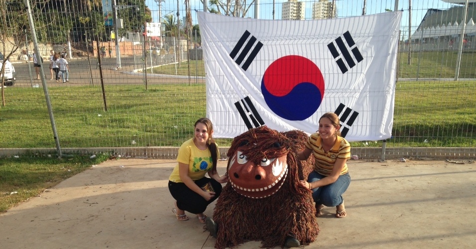 Torcedoras se divertem com mascote antes do início de Rússia x Coreia do Sul, na Arena Pantanal