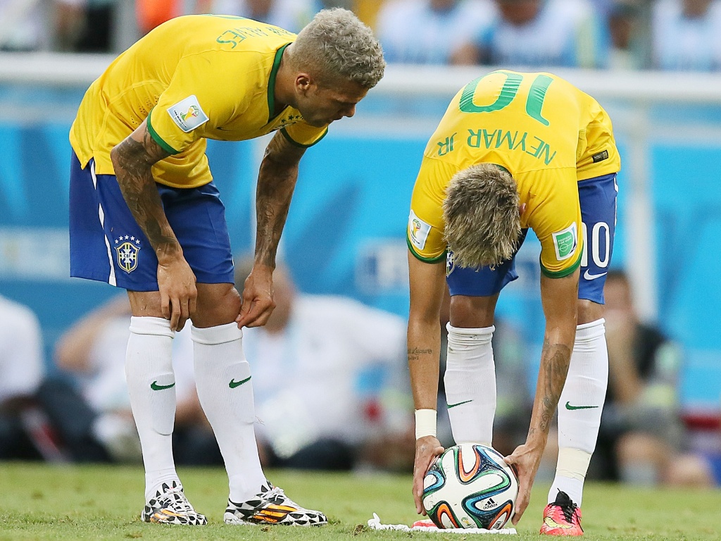 17.jun.2014 - Ao lado de Daniel Alves, Neymar ajeita a bola para cobrar falta contra o México