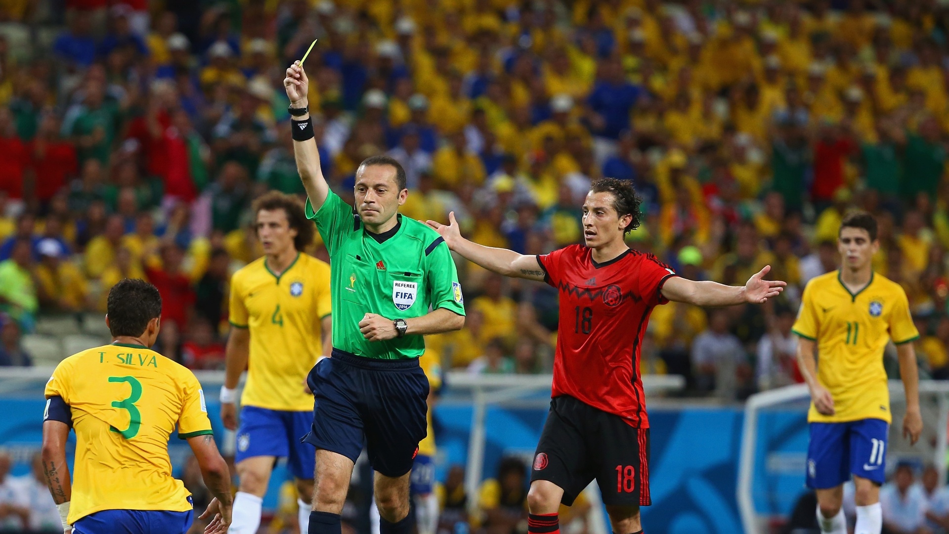 17.jun.2014 - Árbitro Cuneyt Cakir mostra o cartão amarelo para Thiago Silva após o zagueiro cometer falta na entrada da área
