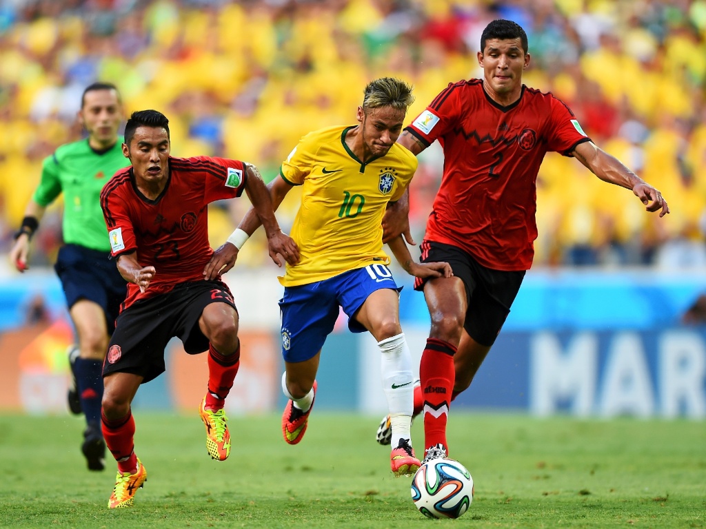 17.jun.2014 - Neymar arranca com a bola e escapa da marcação de dois mexicanos no Castelão