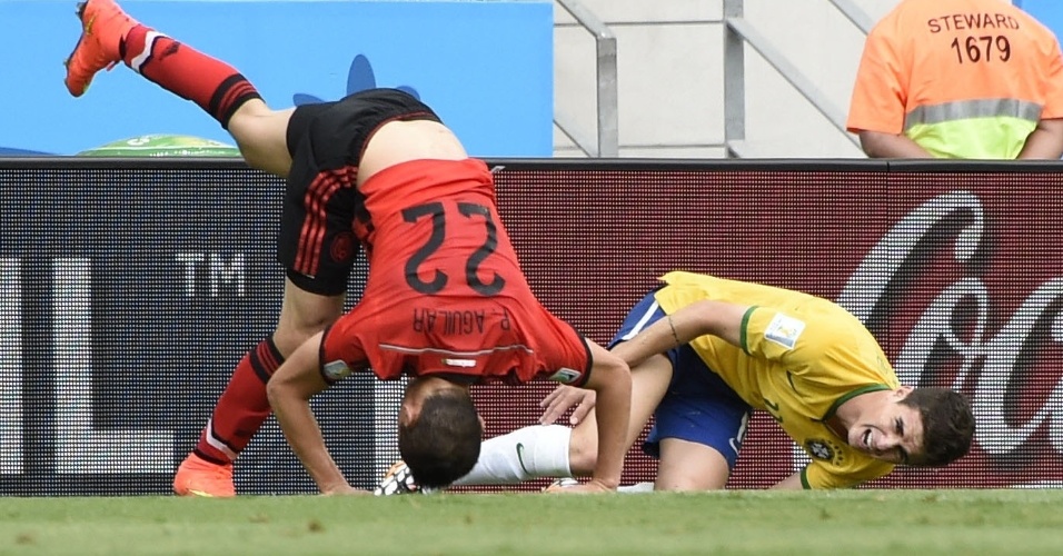 17.jun.2014 - Oscar e mexicano Paul Aguilar dividem a bola e ficam caídos no gramado do Castelão