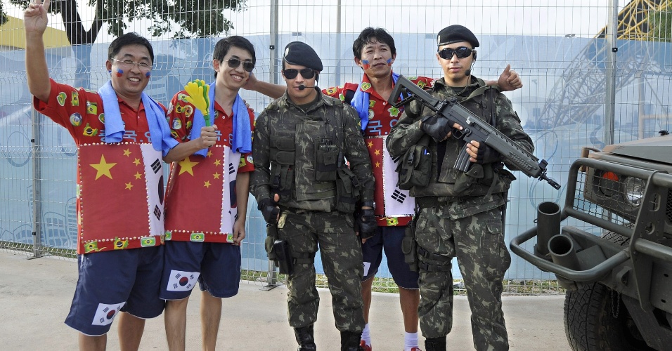 Torcedores sul-coreanos tiram fotos com homens do Exército antes de jogo entre Rússia e Coreia do Sul, na Arena Pantanal