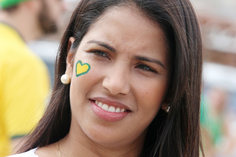 Torcedora pinta coração com as cores do Brasil para apoiar a seleção contra o México