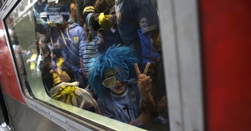 19.jun.2014 - Torcedor uruguaio faz sinal de vitória no trem com destino ao Itaquerão