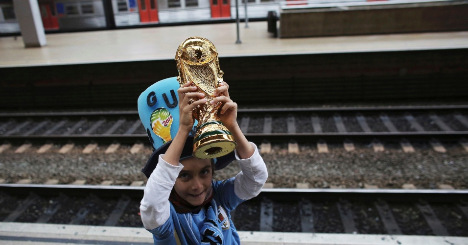 19.jun.2014 - Criança torcedora do Uruguai levanta a taça da Copa do Mundo na estação da Luz, aguardando trem com destino ao Itaquerão, na zona leste de São Paulo