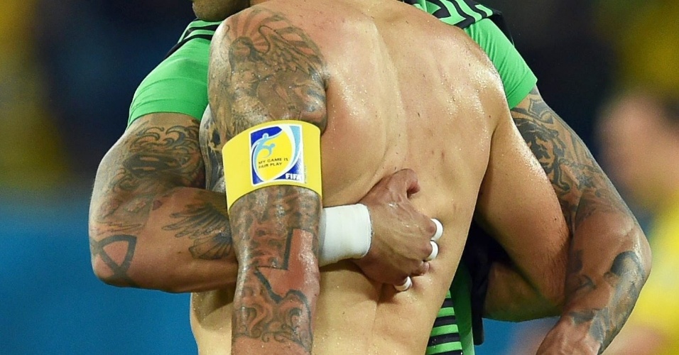 Norte-americanos Clint Dempsey (e) e Tim Howard revelam suas tatuagens ao fim do jogo contra Gana