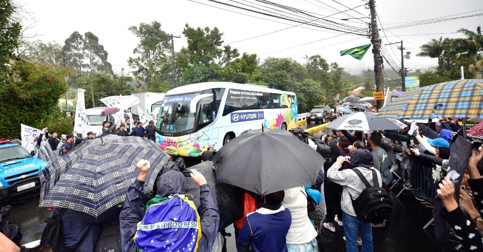 O ônibus da seleção chegou escoltado, sob chuva e foi recebido por dezenas de torcedores na Granja Comary