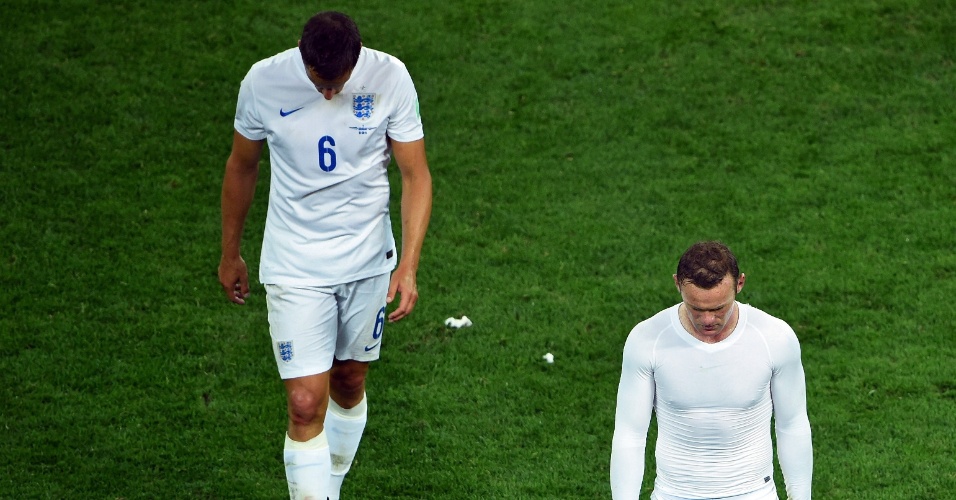 19.jun.2014 - Phil Jagielka (esquerda) e Wayne Rooney deixam o gramados cabisbaixos após a derrota da Inglaterra no Itaquerão