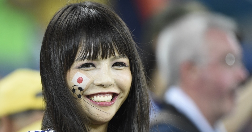 Torcedora japonesa sorri para a câmera durante jogo entre Japão e Grécia na Arena das Dunas