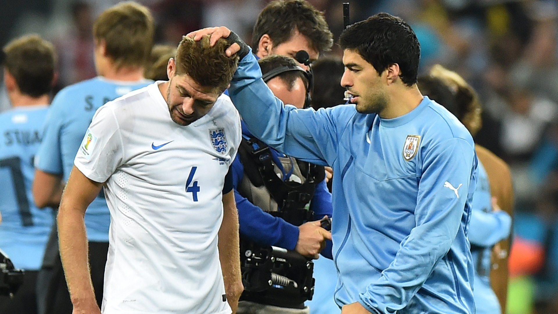 19.jun.2014 - Uruguaio Suárez consola o inglês Gerard, companheiro de Liverpool, após a vitória dos sul-americanos por 2 a 1