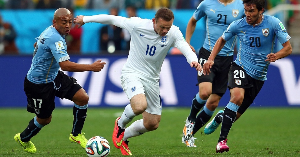 19.jun.2014 - Vaiado antes do jogo pela torcida no Itaquerão, inglês Wayne Rooney tenta escapar da marcação uruguaia