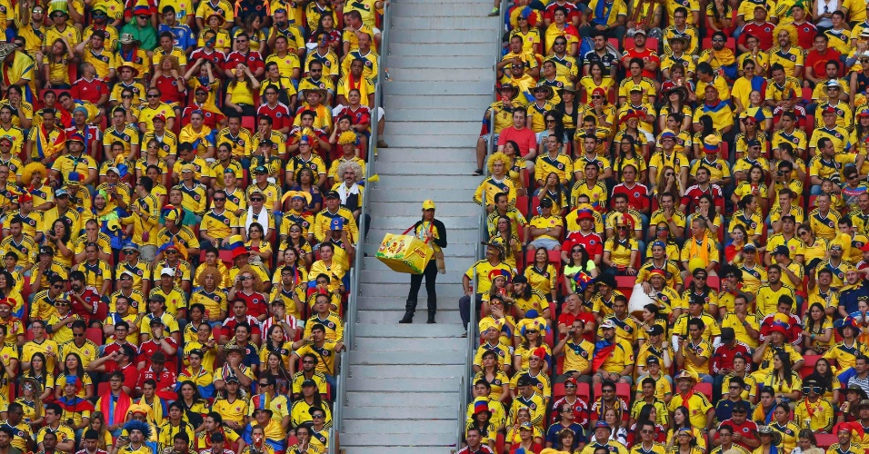 Vendedor caminha pelas escadas do Mané Garrincha em meio ao amarelo colombiano