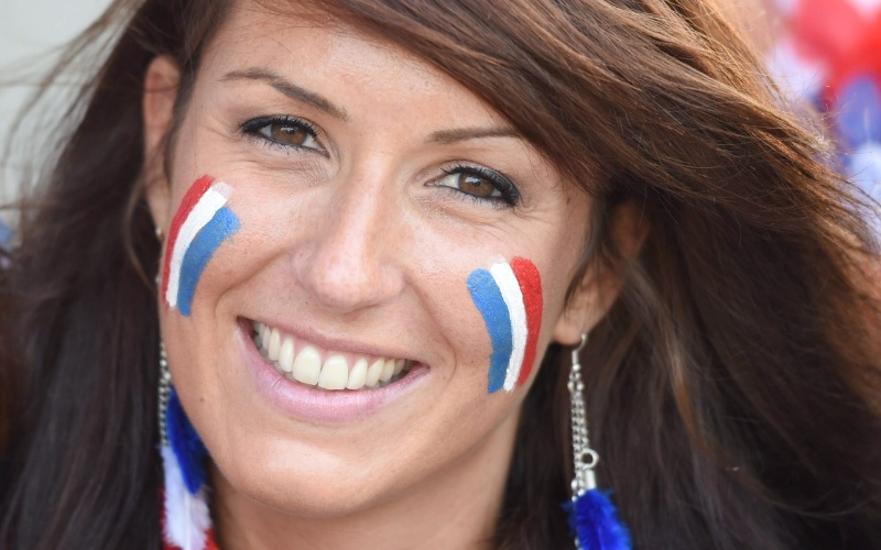 Torcedora com rosto pintado com as cores da França aguarda a partida contra a Suíça