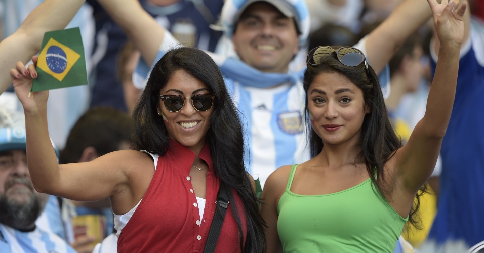 Com a bandeira do Brasil na mão e a do Irã no rosto, belas torcedores assistem ao jogo contra a Argentina no Mineirão