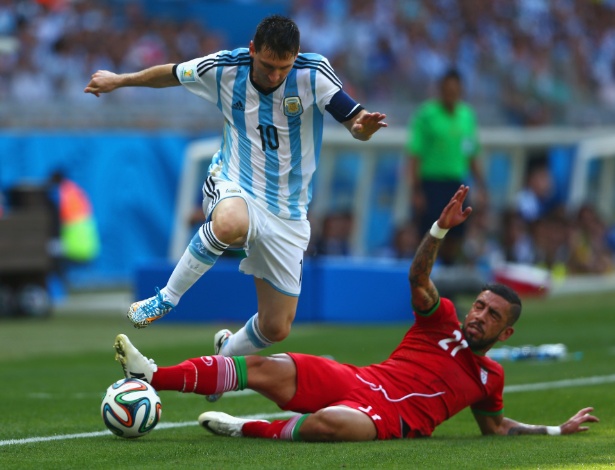 Lionel Messi pula para escapar de carrinho de Ashkan Dejagah durante a partida entre Argentina e Irã
