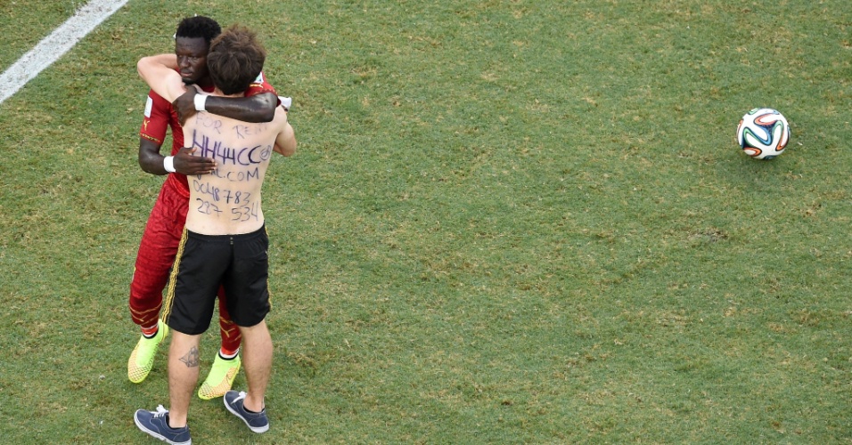 21.jun.2014 - Sulley Muntari, de Gana, abraça torcedor que invadiu o gramado na partida contra a Alemanha, no Castelão