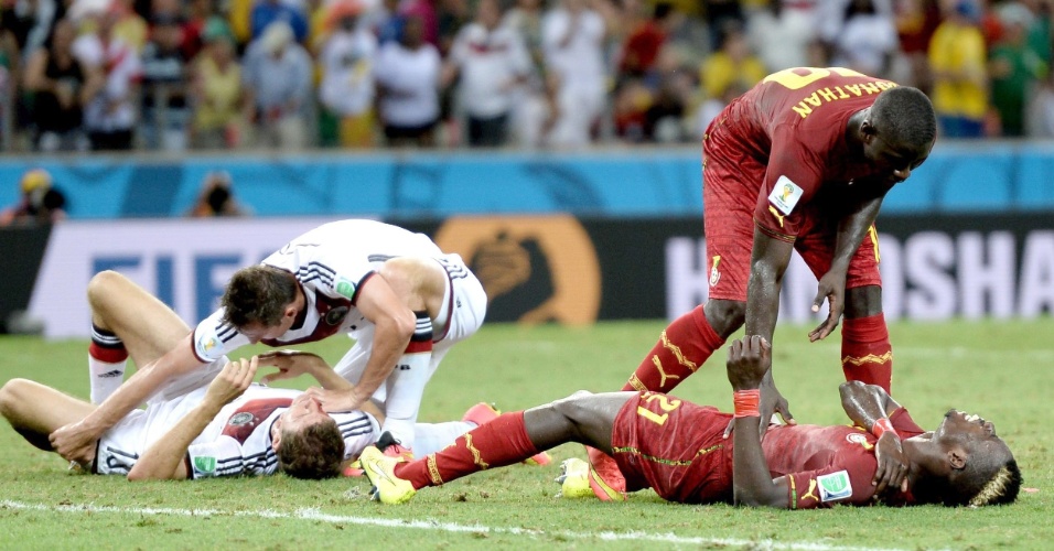 21.jun.2014 - Thomas Müller, da Alemanha, e John Boye, de Gana, ficam caídos no gramado após dividida no último lance do empate por 2 a 2