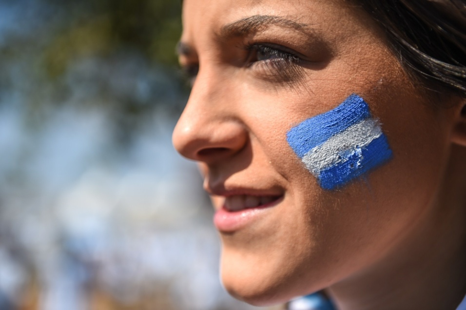 Torcedora pinta o rosto com as cores da bandeira argentina antes do jogo contra o Irã
