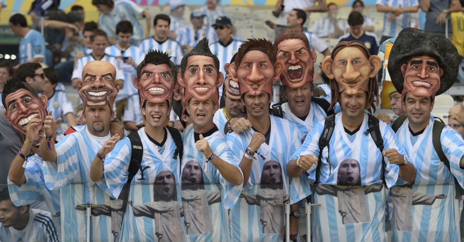 Torcedores usam máscaras com o rosto de jogadores argentinos antes de partida contra o Irã no Mineirão