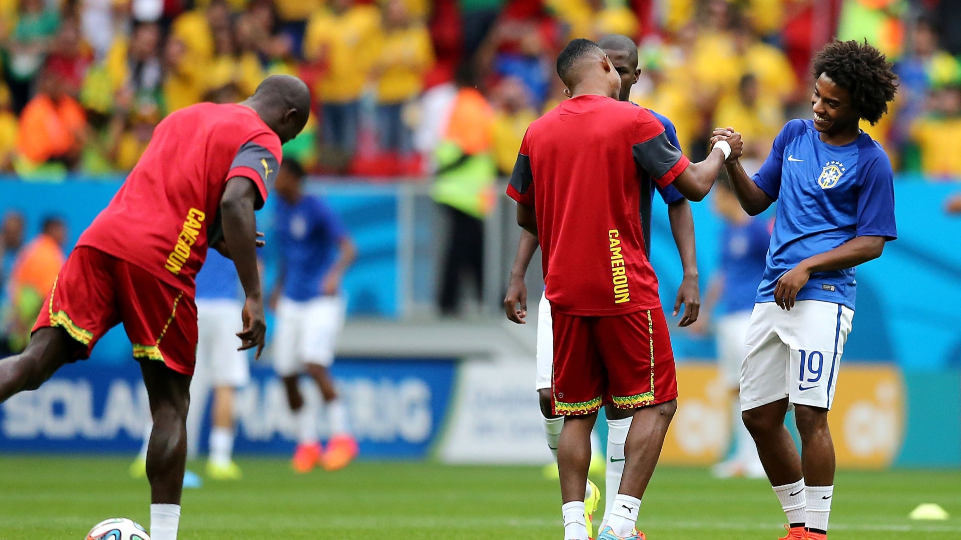 23.jun.2014 - Brasileiro Willian cumprimenta o camaronês Eto'o. Os jogadores são companheiros de Chelsea