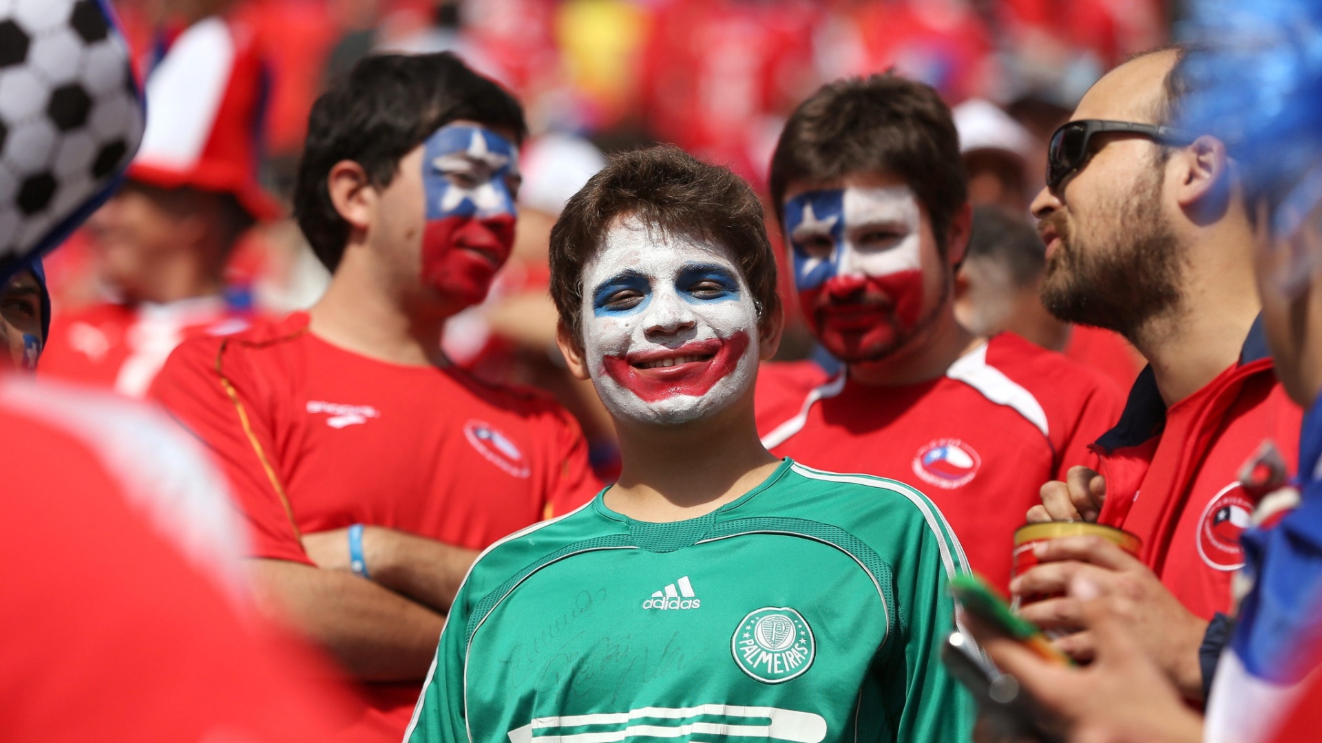 Garoto palmeirense pinta o rosto com as cores do Chile para assistir à partida contra a Holanda, no Itaquerão