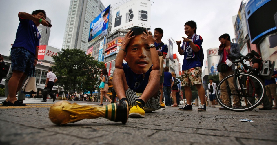 24.jun.2014 - Japonês com máscara do lateral Nagatomo brinca com a eliminação da seleção nacional na primeira fase da Copa do Mundo