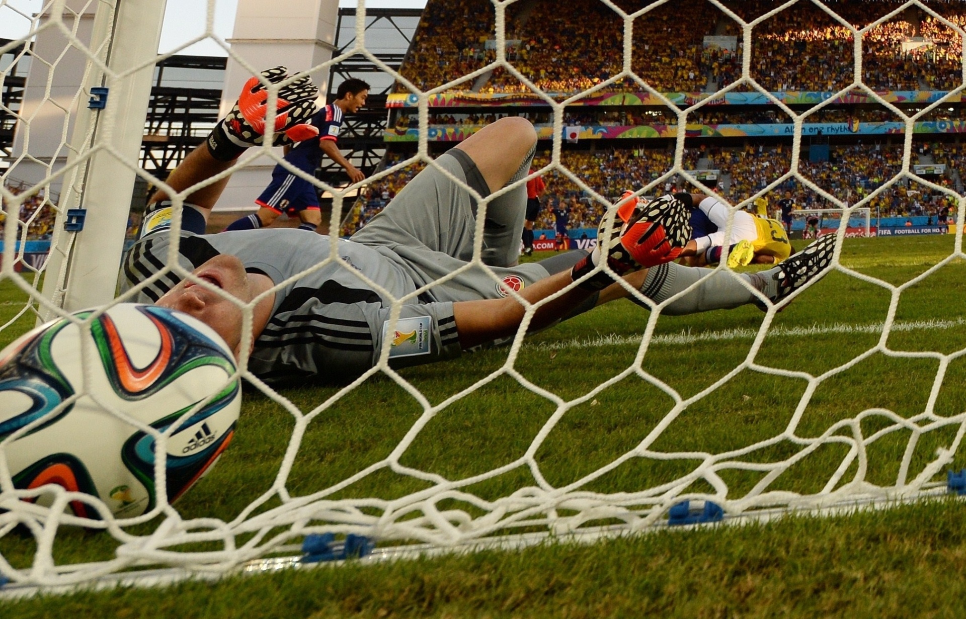 24.jun.2014 - Goleiro colombiano David Ospina vai parar no fundo da rede depois do único gol japonês na vitória por 4 a 1 da Colômbia na Arena Pantanal - undefined