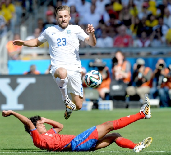 Luke Shaw salta para fugir do carrinho de Yeltsin Tejeda no jogo entre Inglaterra e Costa Rica