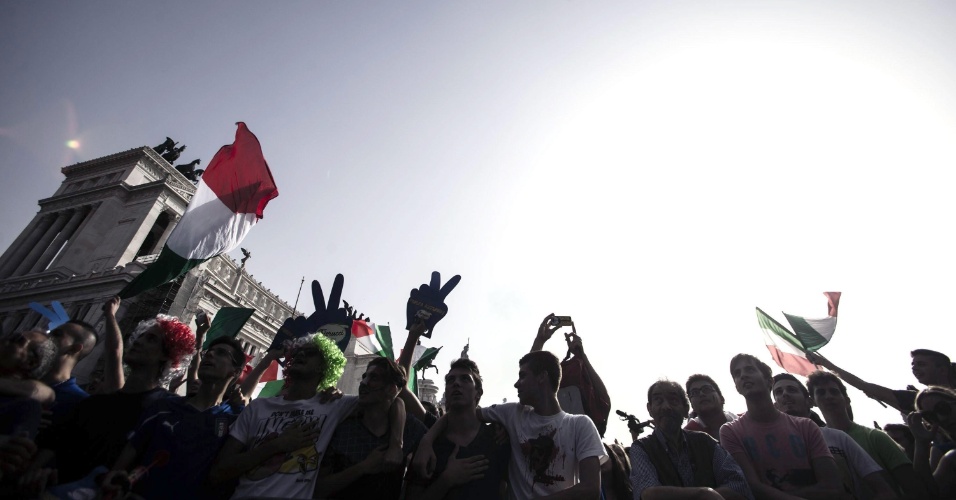 Torcedores italianos agitam bandeiras durante transmissão da partida contra o Uruguai na Piazza Venezia