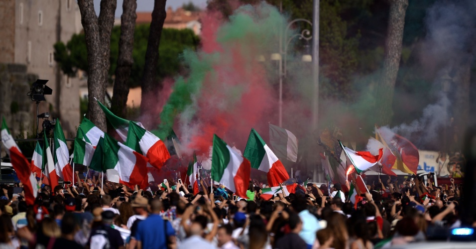 Torcedores italianos agitam bandeiras durante transmissão da partida contra o Uruguai na Piazza Venezia