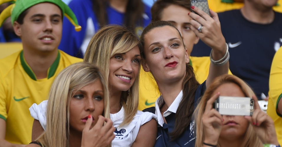 Fiona Cabaye (à esq.), mulher do jogador francês Yohan Cabaye, tira foto nas arquibancadas do Maracanã durante jogo contra o Equador
