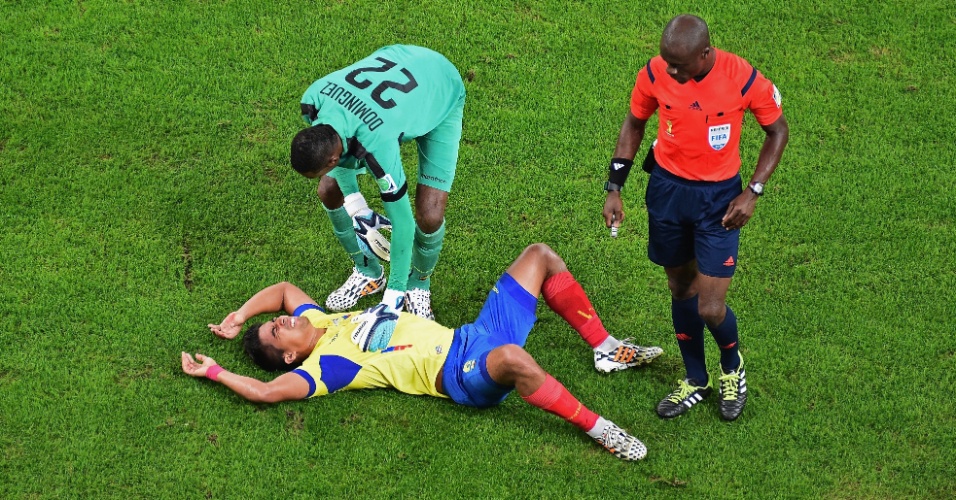 25.jun.2014 - Goleiro Alexander Dominguez, do Equador, ajuda o companheiro Christian Noboa após dividida na partida contra a França
