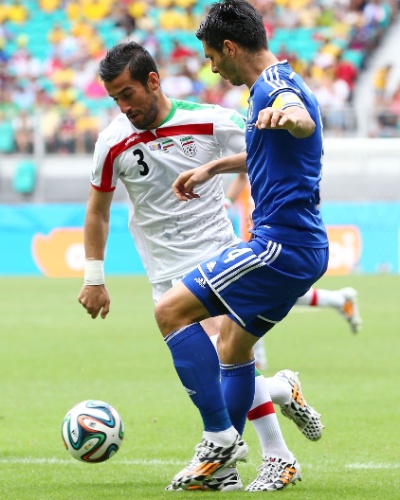 Jalal Hosseini, do Irã, disputa bola com Emir Spahic, da Bósnia, no último jogo dos times na fase de grupos, em Salvador