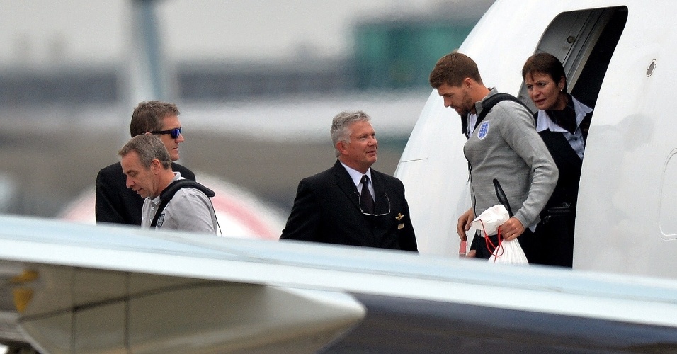 Steven Gerrard chega ao aeroporto de Manchester com a delegação inglesa após eliminação precoce na Copa do Mundo