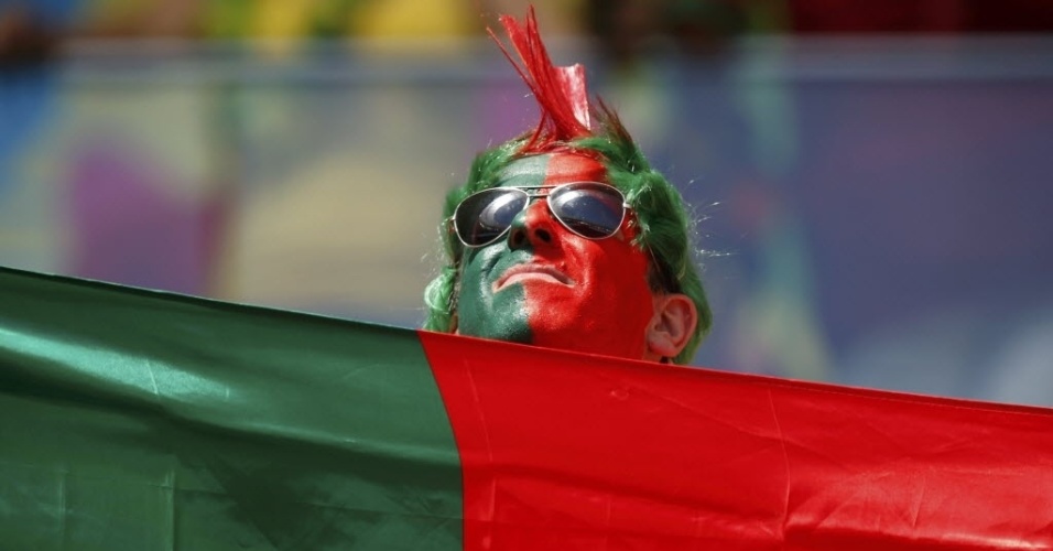 Com rosto pintado, torcedor português fica 'camuflado' na bandeira de seu país (26.jun.2014)