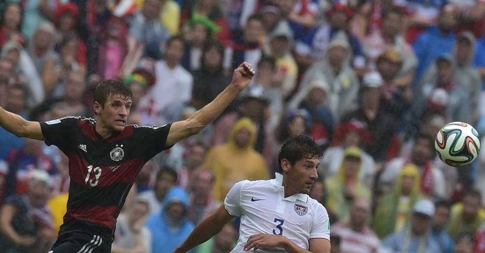 26.jun.2014 - Autor do gol da vitória da Alemanha, Müller observa a bola ao lado do americano Omar Gonzalez durante a partida na Arena Pernambuco