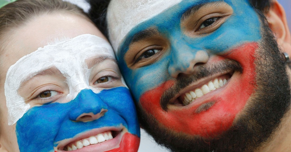Casal russo pinta o rosto com as cores da bandeira e torce unido contra a Argélia, na Arena da Baixada
