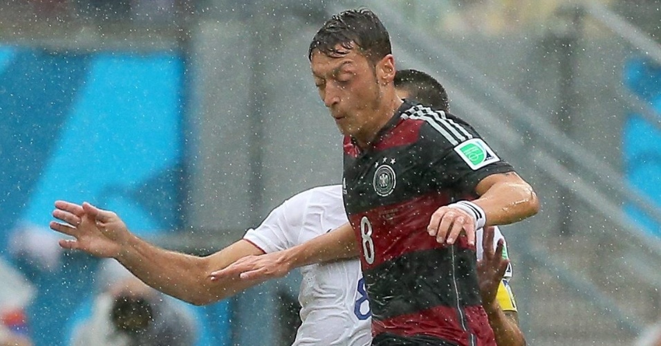 26.jun.2014 - Özil, da Alemanha, e Clint Dempsey, dos EUA, encaram a chuva na Arena Pernambuco