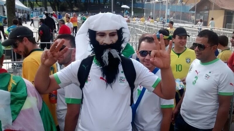 Torcedor usa máscara de árabe barbado para torcer pela Argélia contra a Rússia, na Arena da Baixada