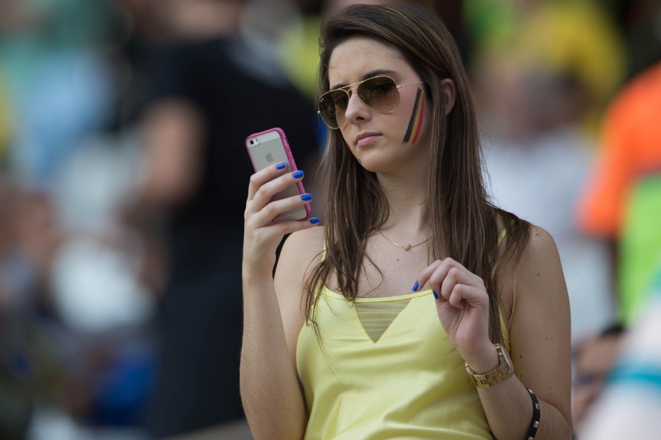 Torcedora olha para o celular antes do jogo entre Bélgica e Coreia do Sul no Itaquerão