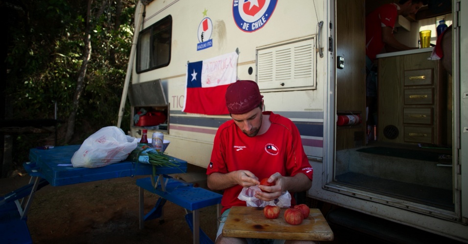 Chileno Pedro Orzua, de 26 anos, prepara uma salada em frente a van estacionada no Parque Lagoa do Nado, em Belo Horizonte, onde torcedores estão acampados