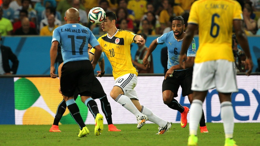 Colombiano James Rodríguez tenta escapar da marcação de uruguaios durante jogo pelas oitavas de final