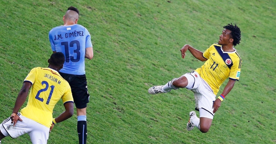 Cuadrado, da Colômbia, sobe para disputar bola com defesa do Uruguai