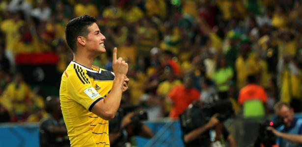 James Rodríguez exibe escudo da Colômbia após marcar o segundo sobre o Uruguai