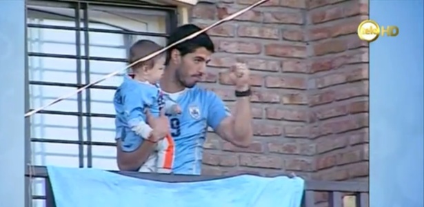 Suárez acena para torcedores que se reuniram em frente à sua casa para ver o jogo do Uruguai