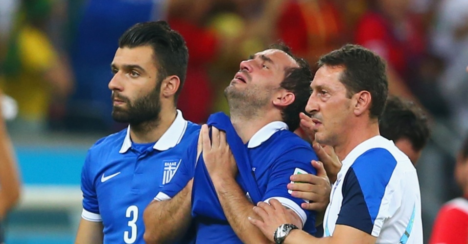 Chorando muito, Gekas é consolado por companheiros após perder pênalti na derrota da Grécia para a Costa Rica
