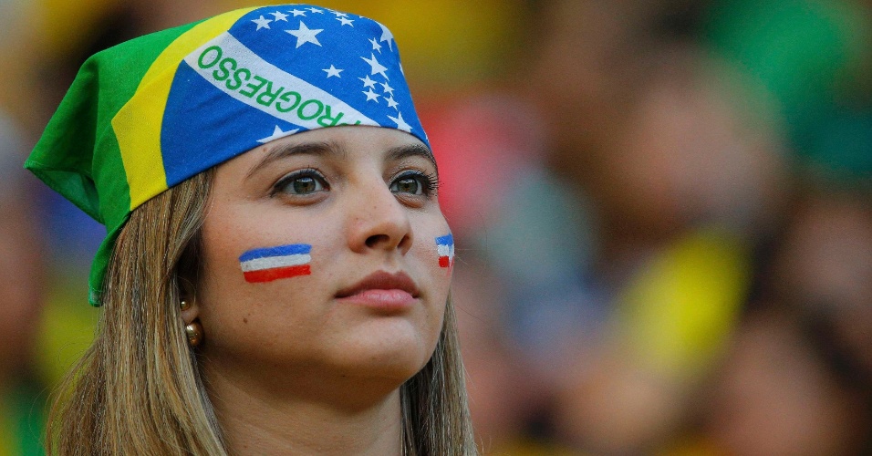 Torcedora com a bandana do Brasil pinta a bandeira da Costa Rica no rosto na Arena Pernambuco