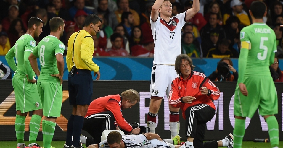 30.jun.2014 - Alemão Mustafi sente lesão e fica caído no gramado, enquanto Mertesacker pede sua substituição contra a Argélia